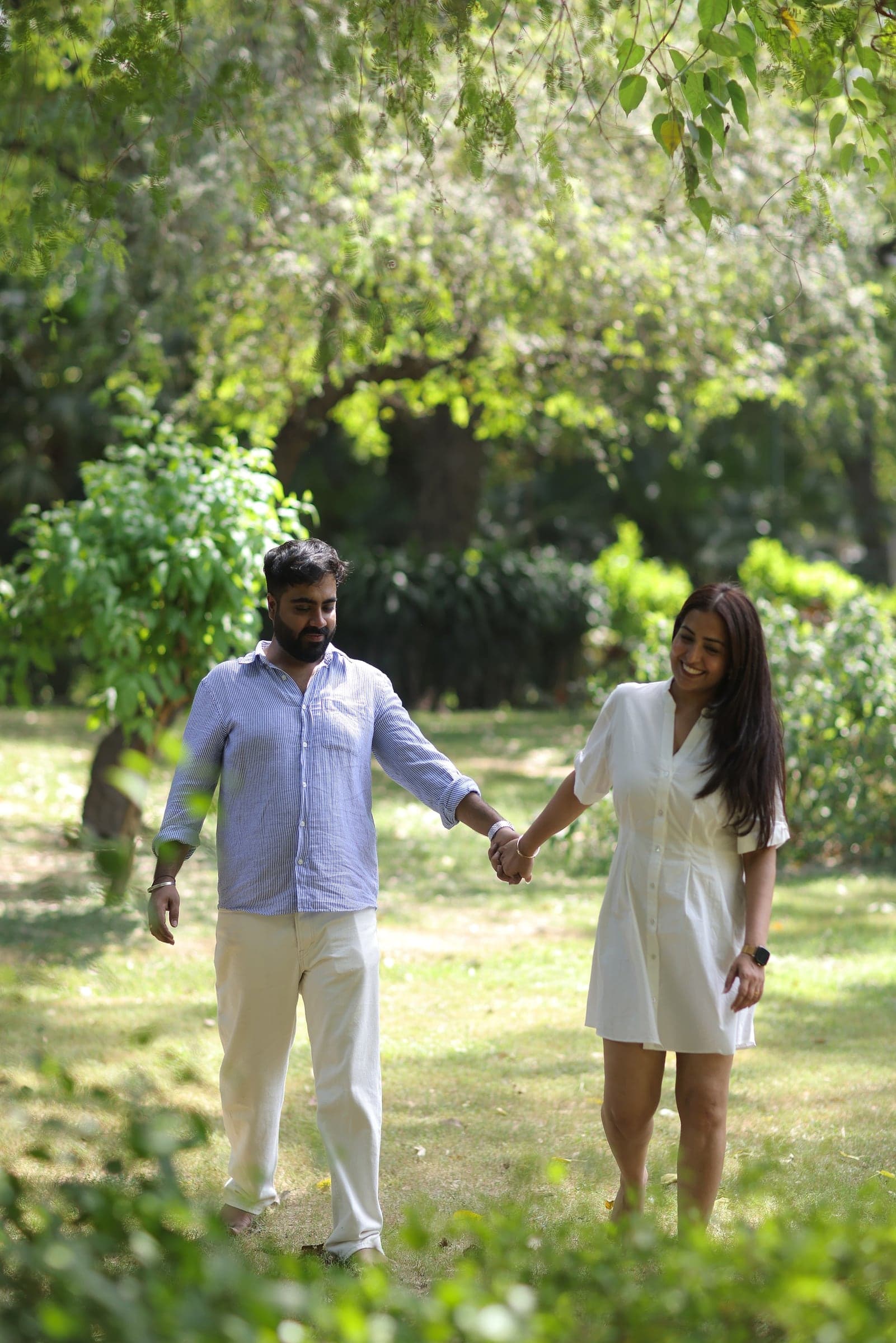 Disha and Mayank walking hand in hand under the trees