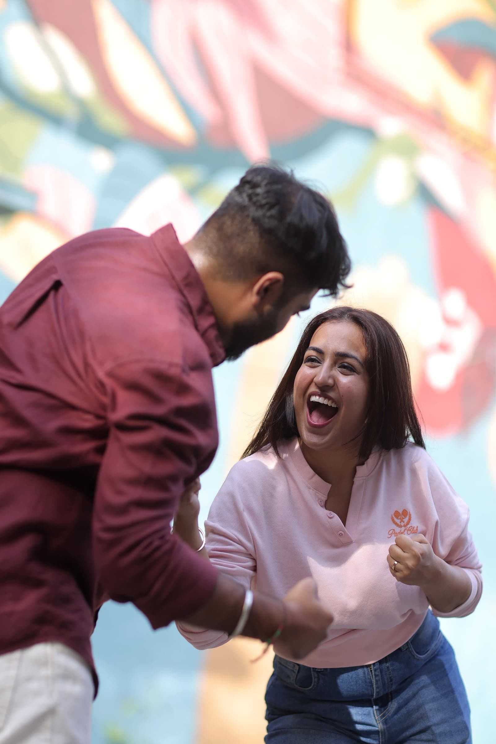 Disha laughing with Mayank by a painted wall