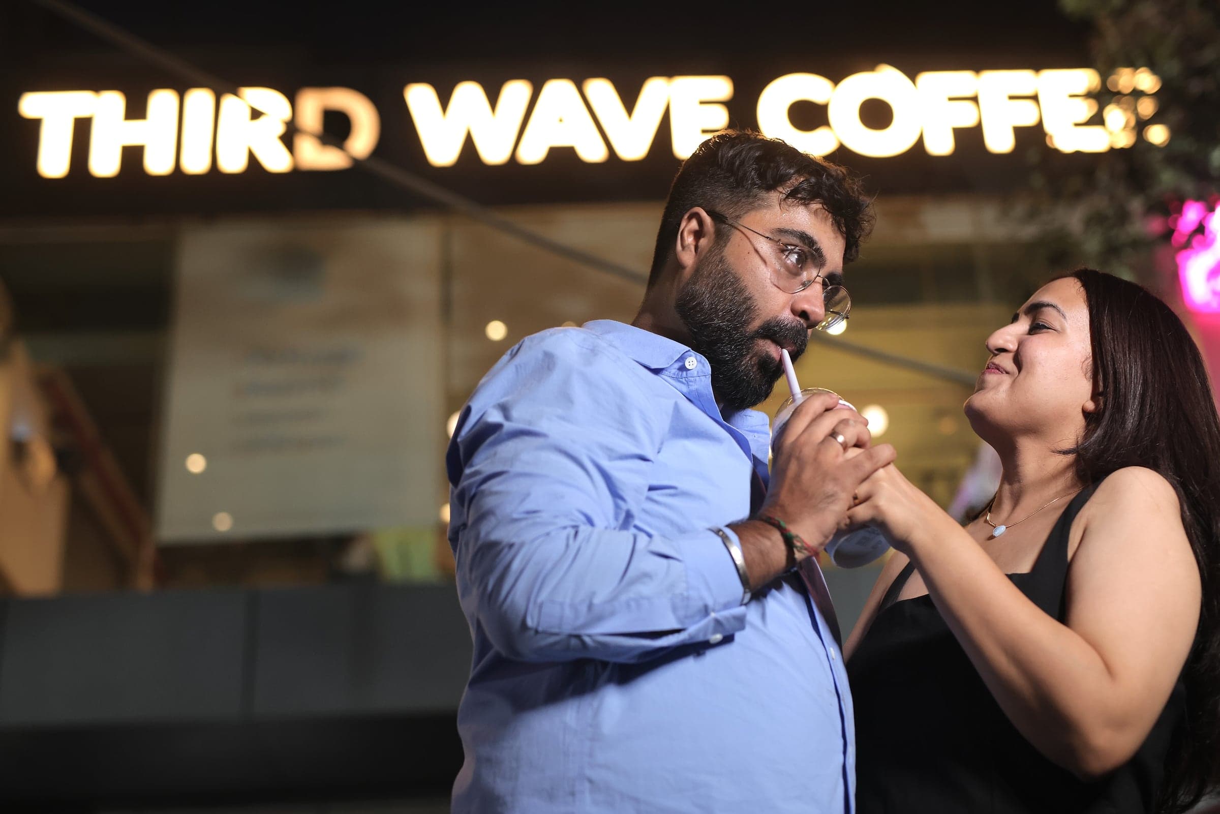 Disha and Mayank sharing a drink outside a café